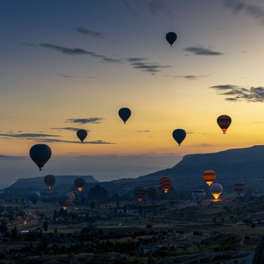 GOREME/TURKEY - June 29, 2022: hot air balloons fly over the city of goreme at sunrise. Turkey.