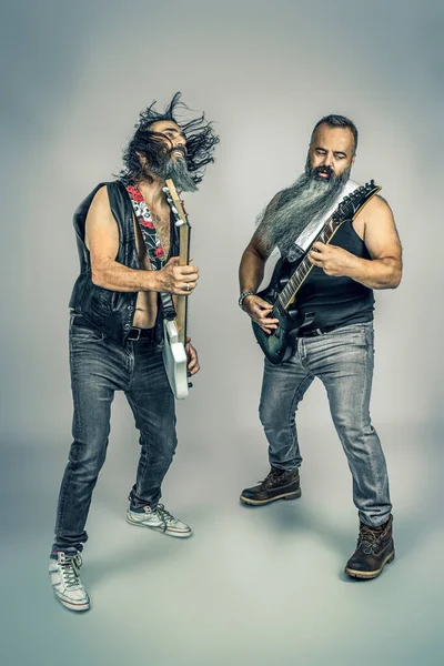 髭の長いロック奏者がベースとギターを弾きスタジオで撮影し — ストック写真