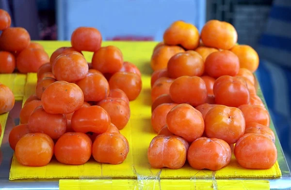 Dojrzałe persimmons na sprzedaż na rynku — Zdjęcie stockowe