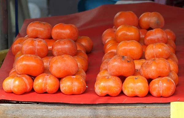 Persimmons maduros para venda no mercado — Fotografia de Stock