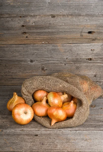 Onions on wooden background — Stock Photo, Image