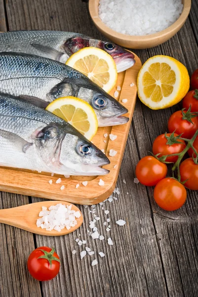 Fresh sea bass on chopping board — Stock Photo, Image