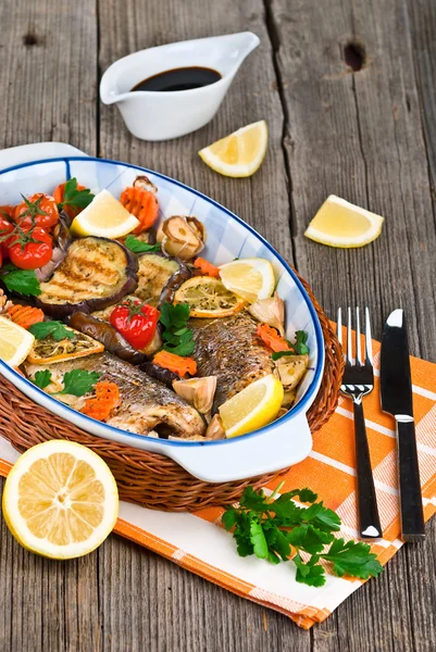 Seabass fish baked with vegetables, herbs and lemon — Stock Photo, Image