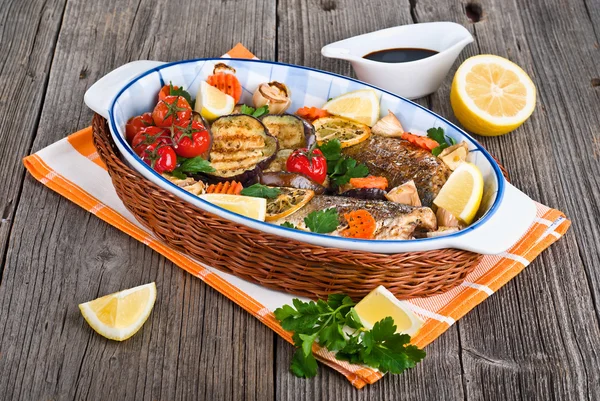 Seabass fish baked with vegetables, herbs and lemon — Stock Photo, Image