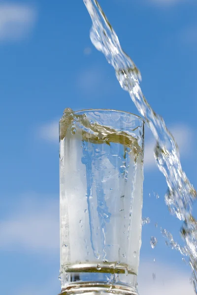 Bicchiere d'acqua e cielo blu . — Foto Stock