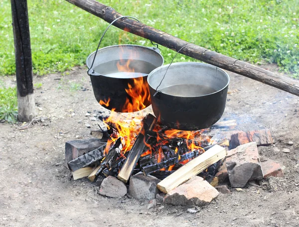 Two pot hanging over the fire