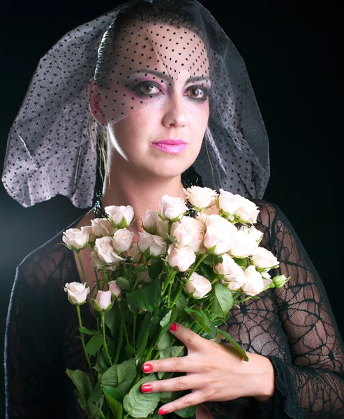 Fille dans un voile noir avec des roses roses — Photo