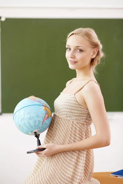 Учитель в школе с глобусом — стоковое фото