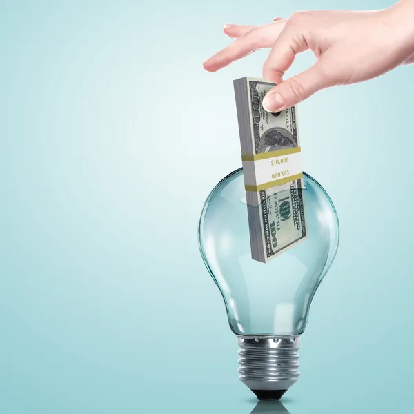 Dinheiro dentro de uma lâmpada elétrica — Fotografia de Stock
