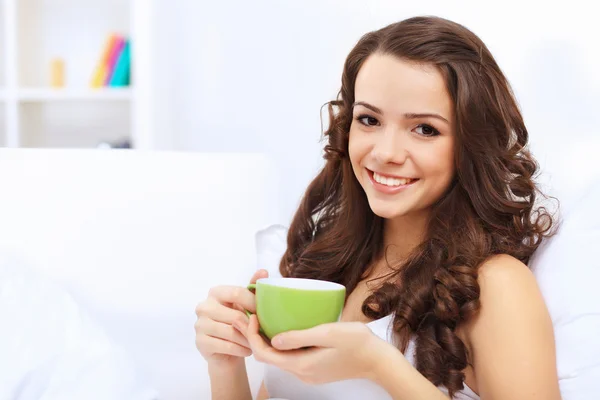 Jovem mulher tomando xícara de chá em casa — Fotografia de Stock