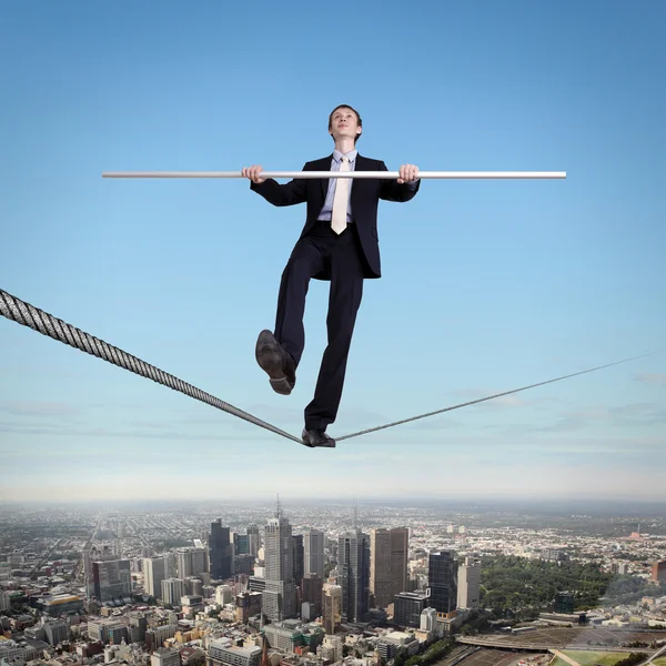Balancing businessman and cityscape — Stock Photo, Image