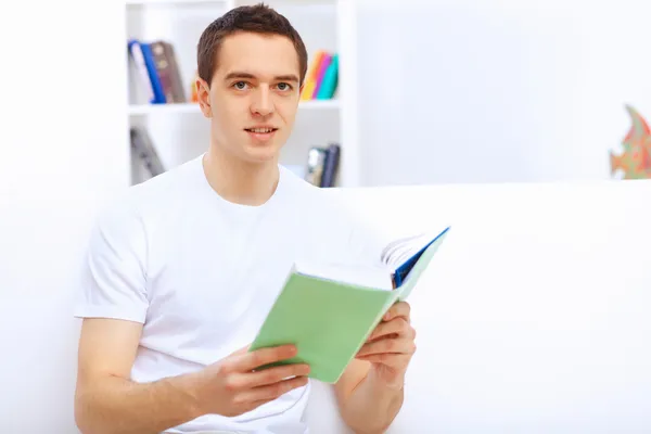 Junger Mann zu Hause mit einem Buch — Stockfoto