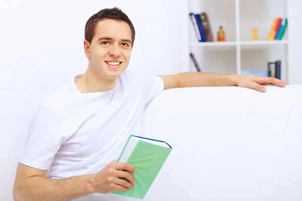 Jovem em casa com um livro — Fotografia de Stock