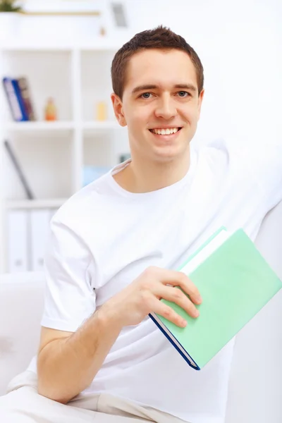 Jeune homme à la maison avec un livre — Photo