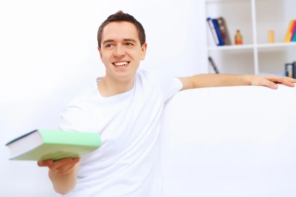 Jovem em casa com um livro — Fotografia de Stock