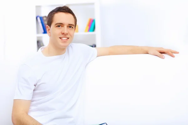 Jeune homme à la maison avec un livre — Photo