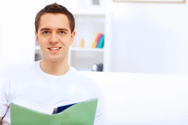 Young man at home with a book — Stock Photo, Image