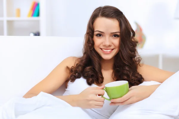 Junge Frau bei einer Tasse Tee zu Hause — Stockfoto