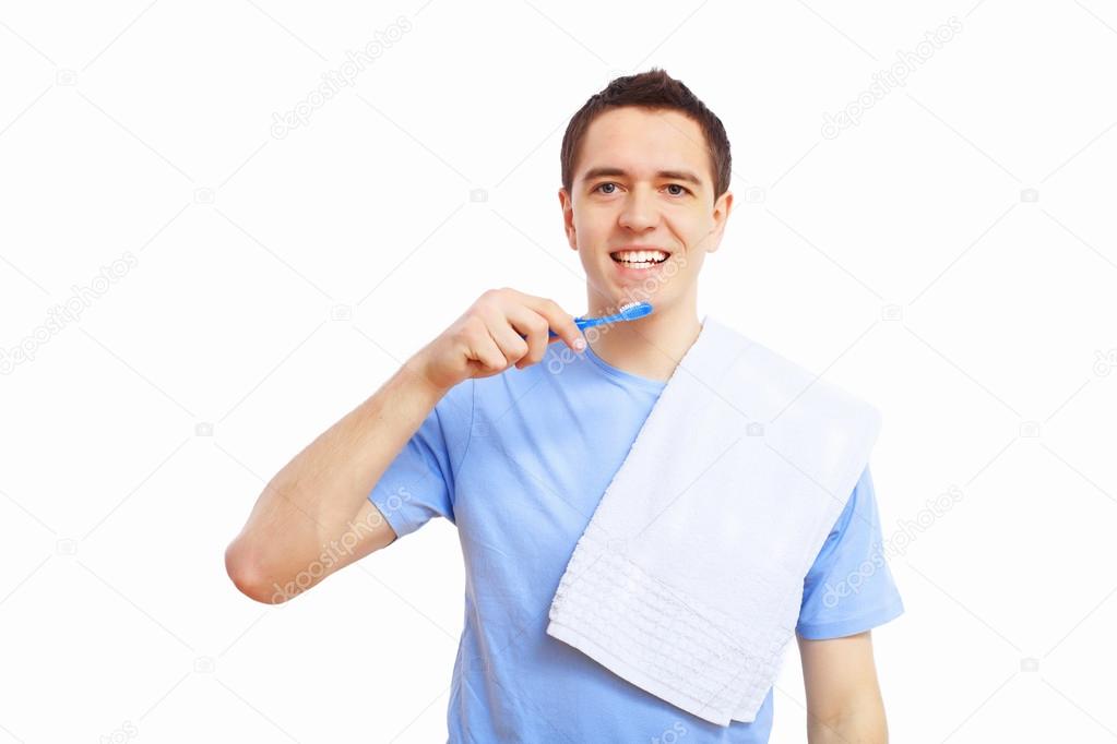 Young man at home brushing teeth