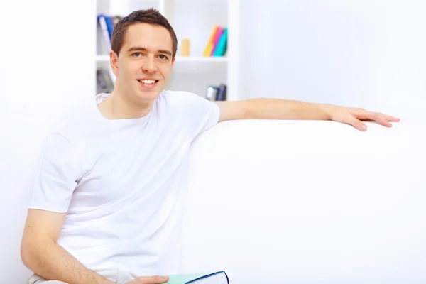 Young man at home with a book — Stock Photo, Image