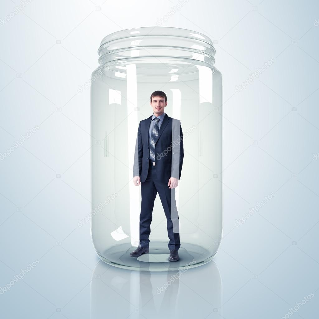 Businessman inside glass jar