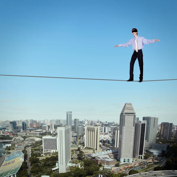 Balancing businessman and cityscape — Stock Photo, Image