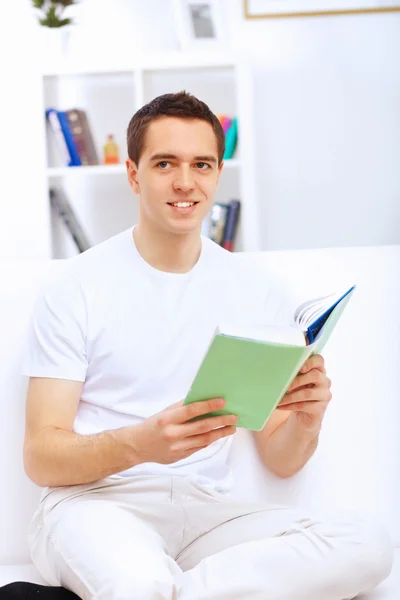 Jeune homme à la maison avec un livre — Photo