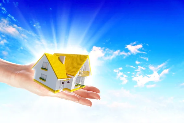 The house in hands on blue sky — Stock Photo, Image