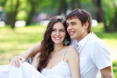 Mavi gökyüzü altında gülümseyen genç aşk Çift