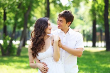 Mavi gökyüzü altında gülümseyen genç aşk Çift