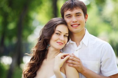 Mavi gökyüzü altında gülümseyen genç aşk Çift