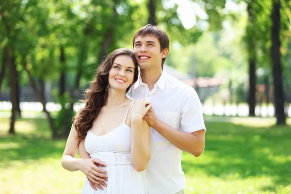 Mavi gökyüzü altında gülümseyen genç aşk Çift