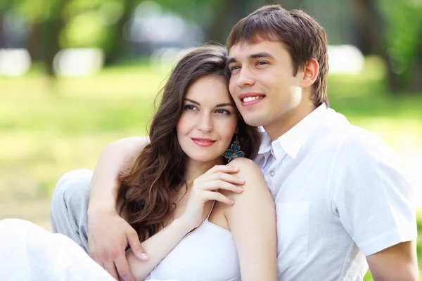 Jonge liefde paar glimlachend onder de blauwe hemel — Stockfoto