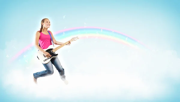 Young woman playing on electro guitar and jumping — Stock Photo, Image