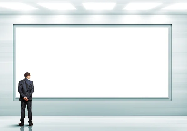 Business person standing near a blank billboard — Stock Photo, Image