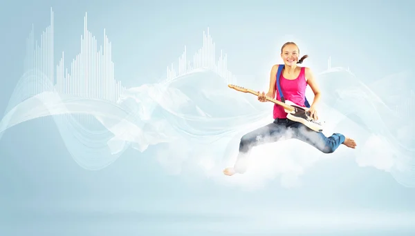 Mujer joven tocando en la guitarra eléctrica y saltando —  Fotos de Stock