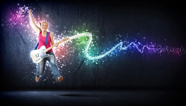 Jeune femme jouant à la guitare électro et sautant — Photo