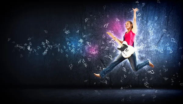 Νεαρή γυναίκα που παίζει στην κιθάρα electro και άλμα — Φωτογραφία Αρχείου