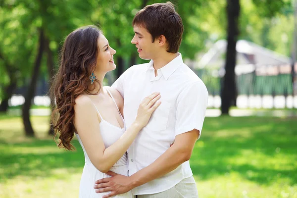 Mavi gökyüzü altında gülümseyen genç aşk Çift