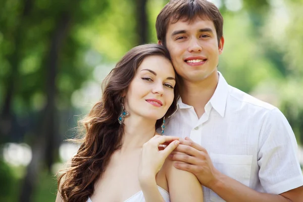 Jonge liefde paar glimlachend onder de blauwe hemel — Stockfoto