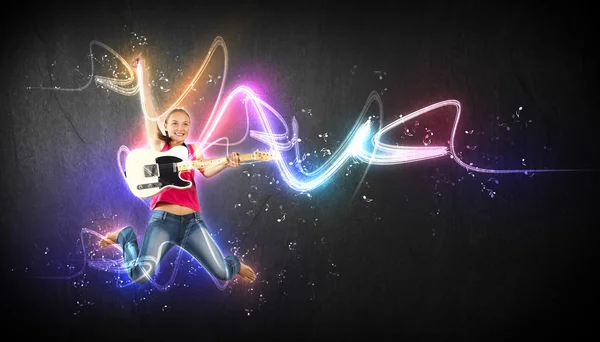 Young woman playing on electro guitar and jumping — Stock Photo, Image