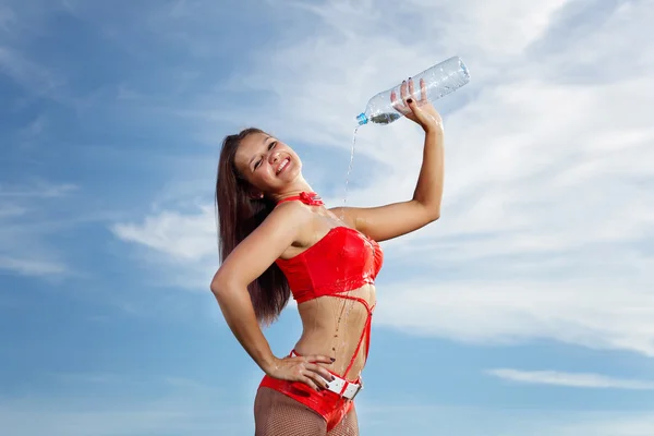 Junge Sportlerin mit einer Flasche Wasser — Stockfoto