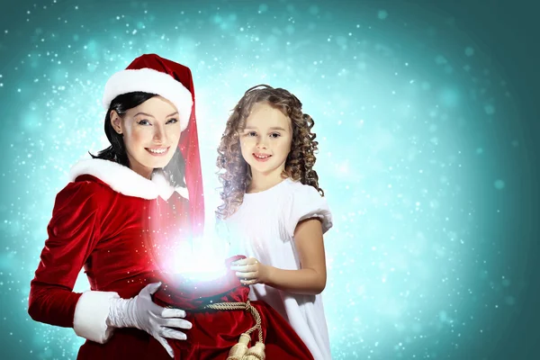 Kleines Mädchen mit Weihnachtsgeschenken und Weihnachtsmann — Stockfoto