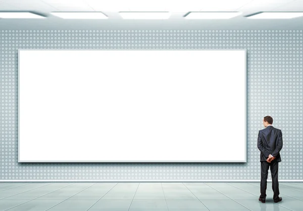 Business person standing near a blank billboard — Stock Photo, Image