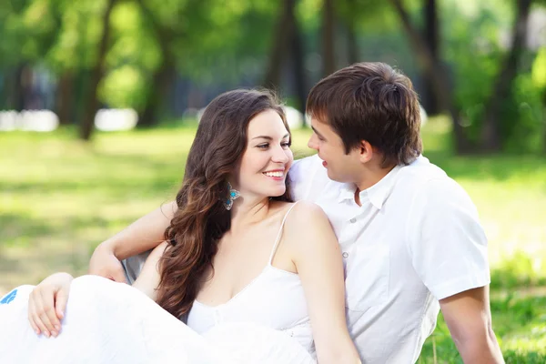 Jonge liefde paar glimlachend onder de blauwe hemel — Stockfoto