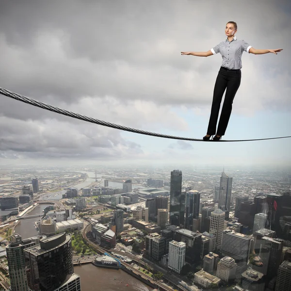 Balancing businesswoman and cityscape — Stock Photo, Image