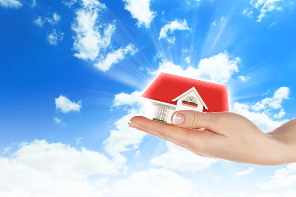 Huset i händerna på blå himmel — Stockfoto