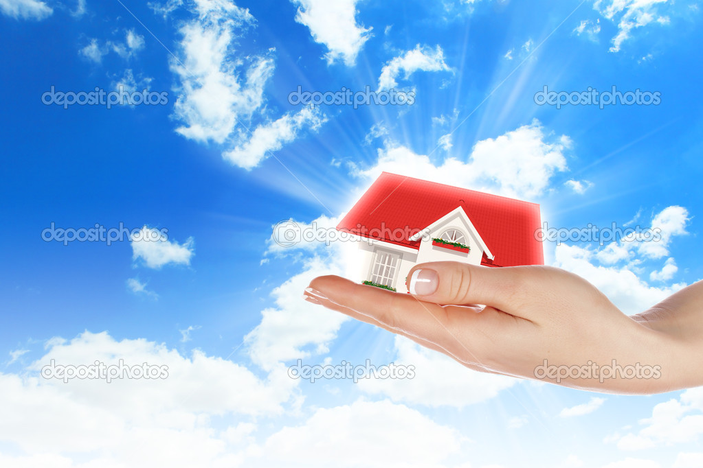 The house in hands on blue sky