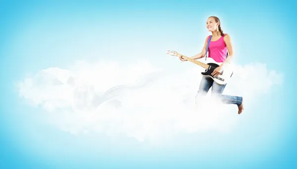 Mujer joven tocando en la guitarra eléctrica y saltando — Foto de Stock