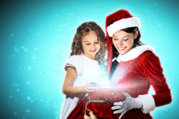 Kleines Mädchen mit Weihnachtsgeschenken und Weihnachtsmann — Stockfoto